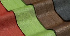 several colors of fabric on top of each other in different sizes and shapes, including black, brown, green, red