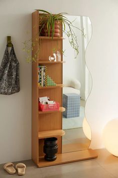 a wooden shelf with a mirror and some shoes on the floor in front of it