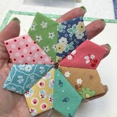 a person holding a bunch of small pieces of fabric