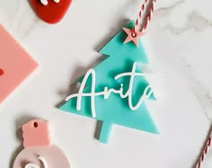 some christmas ornaments are laying on a white table with red and pink decorations around them