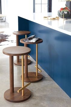 two wooden stools sitting next to each other in front of a blue counter top