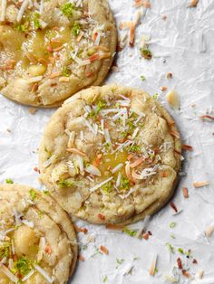 three cookies with different toppings on top of white paper