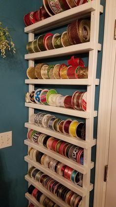 a white shelf filled with lots of different types of tapes and tins on top of it