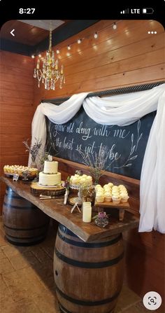 a table with cakes and cupcakes on it in front of a chalkboard