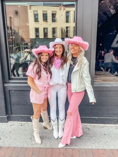 three women in pink outfits posing for a photo