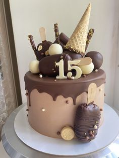 a chocolate cake with ice cream, cookies and an icecream cone on top