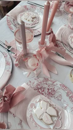 the table is set with pink and white dishes