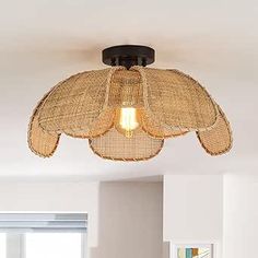 the light fixture is made out of wicker and has a large fan hanging from it's ceiling