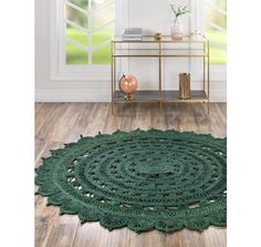 a green rug on the floor in front of a window