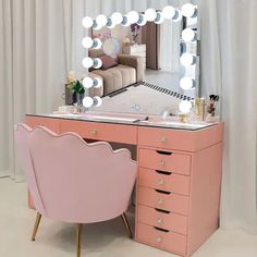 a pink vanity table with a chair and mirror