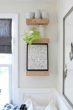 a white room with some plants and pictures on the wall above it, along with other items