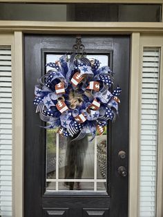 a patriotic wreath on the front door of a house with an american flag and football theme