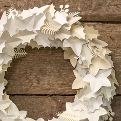 a wreath made out of white paper sitting on top of a wooden table