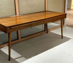 a wooden table sitting in front of two glass doors on either side of the wall