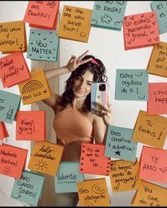 a woman holding a cell phone surrounded by post it notes