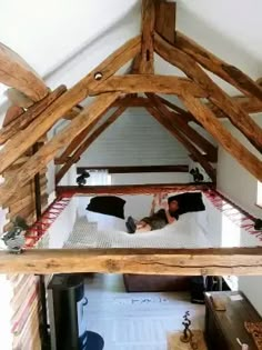 a person laying on top of a bed in a room with wooden beams and walls