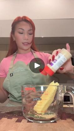 a woman in an apron is mixing food into a blender and adding ingredients to the batter