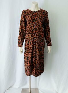 Romantic vintage 1990s draped day dress created by the April Cornell for Cornell Trading label of a soft rayon fabric in a floral design (shades of orange & green against a black background). The three-quarter length sleeved dress has a loose tunic cut with a rounded neckline, buttonfront opening and a midi-length hem with walking slits on each side of the skirt. The dress is unlined. A great layering piece that could be worn so many different ways. MEASUREMENTS: Labeled as a size Medium (it Orange Amp, Loose Tunic, April Cornell, Boho Grunge, Button Front Dress, Sleeved Dress, Rounded Neckline, Floral Vintage, Rayon Fabric