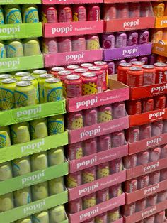 several rows of poppi sodas are stacked on the wall in front of each other