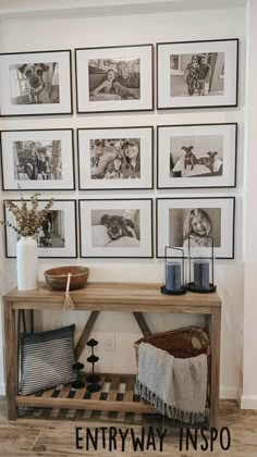 a wooden table with pictures on the wall above it