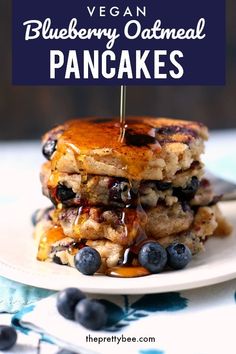 a stack of pancakes with blueberries and syrup being drizzled on top