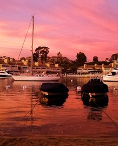 two boats are docked in the water at sunset