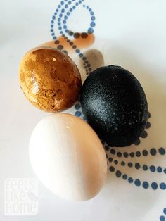 two eggs and one brown egg are on a white plate with blue dots around it