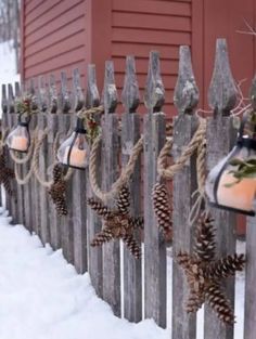 pine cones are hung on the fence with string and hanging from it's posts