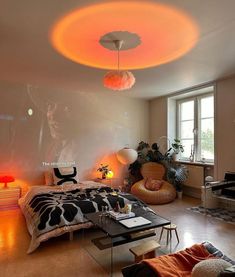 a bedroom with an orange light on the ceiling, and a bed in front of a window