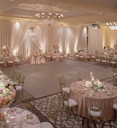 a banquet hall with tables, chairs and chandeliers set up for a formal function