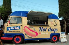 an ice cream truck with hot dogs and snacks on the side is parked in a parking lot