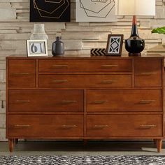 a large wooden dresser sitting in front of a wall with pictures on top of it