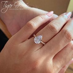 a woman's hand with a diamond ring on her finger and an engagement band