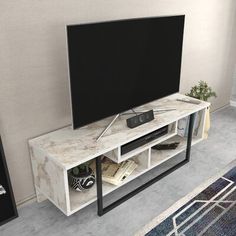 a flat screen tv sitting on top of a white entertainment center