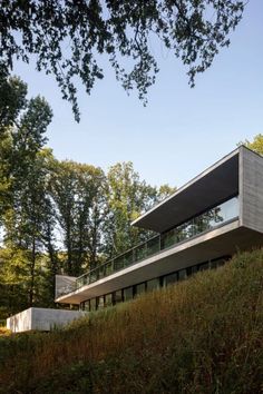 a modern house on top of a hill with trees in the backgroung