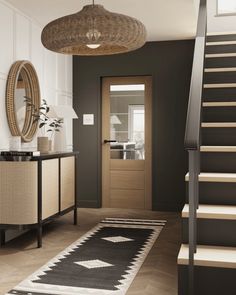 a hallway with stairs, rug and mirror