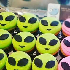 there are many green and pink cupcakes with black eyes