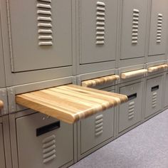 a row of lockers with wooden tops and drawers