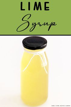 a jar filled with liquid sitting on top of a white table next to a green sign that says lime syrup