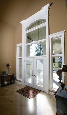 a room with two windows and a rug on the floor