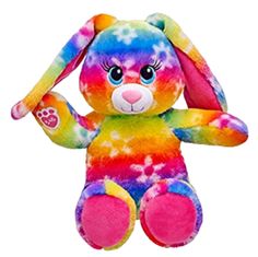 a rainbow colored stuffed animal sitting on top of a white background