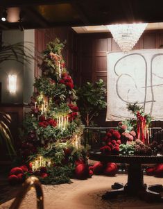 a decorated christmas tree sitting in the middle of a room next to a table with decorations on it