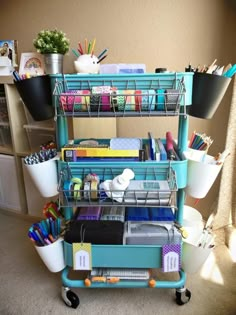 a blue cart filled with lots of office supplies on top of a carpeted floor