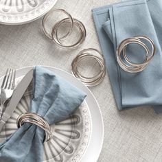 a place setting with napkin rings and silverware