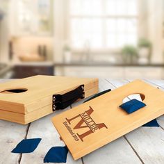 two cornhole game pieces on a wooden table with blue ribbon around the edges and one piece missing