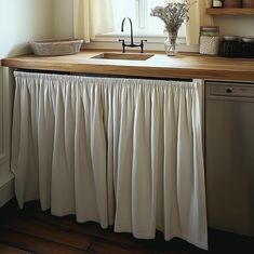 a kitchen with a sink, dishwasher and window