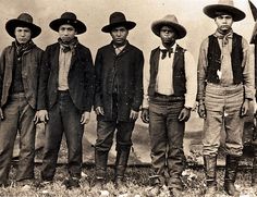 an old black and white photo of five men wearing hats, standing next to each other