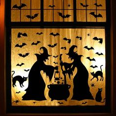 a stained glass window decorated with halloween silhouettes and witches, bats, and caulders