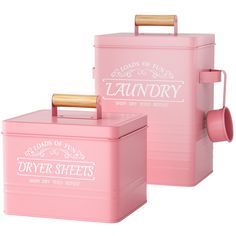 two pink tins with gold handles and labels on them, one has a roll of toilet paper in it