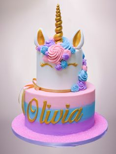 there is a cake that has a unicorn on it and the words olivia written in gold